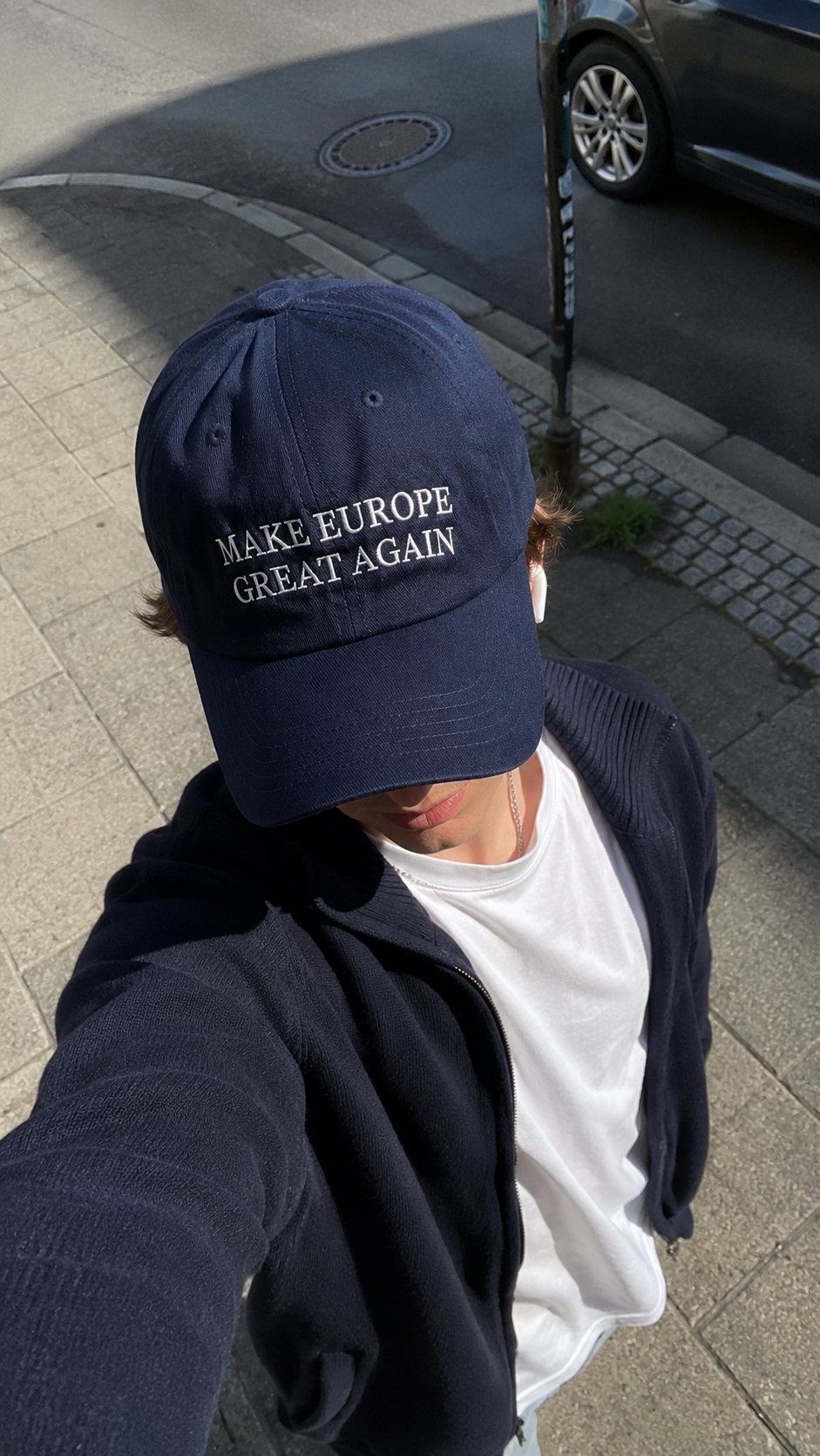 Customer selfie wearing the navy Make Europe Great Again cap outdoors in the sun